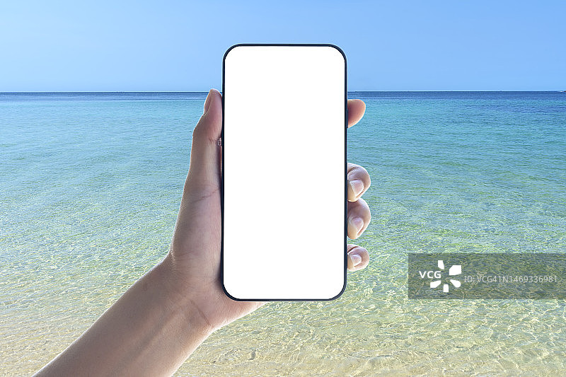 白色屏幕手机与清澈海水沙滩背景图片素材