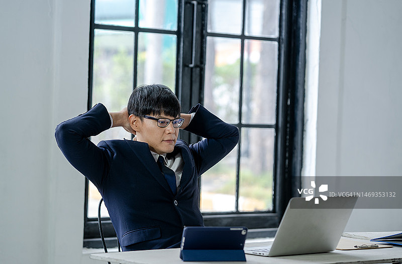 商人坐在办公室放松，快乐的男性在椅子上休息图片素材