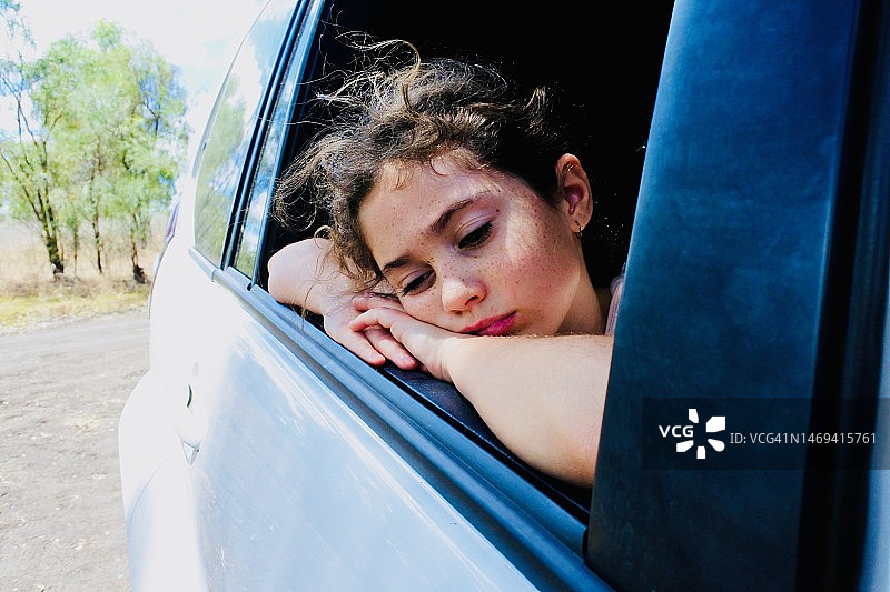 悲伤的年轻女孩在车里旅行图片素材