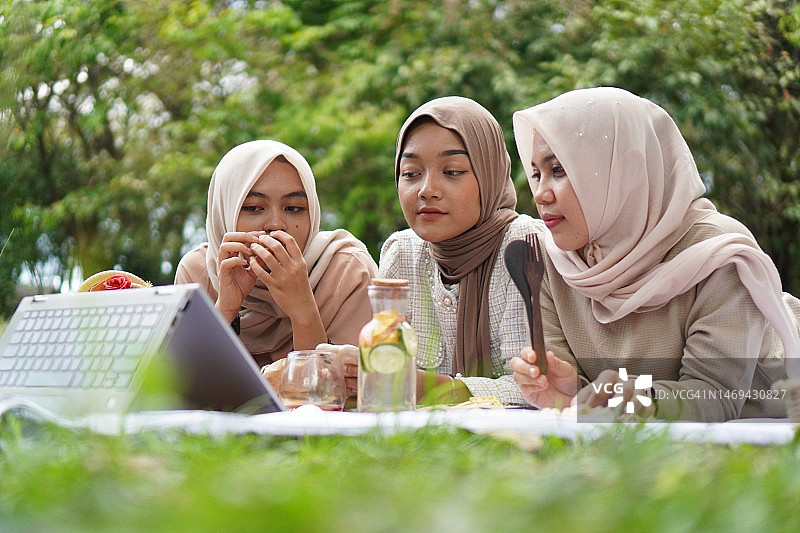 戴着头巾在公园里看电影的漂亮女人图片素材
