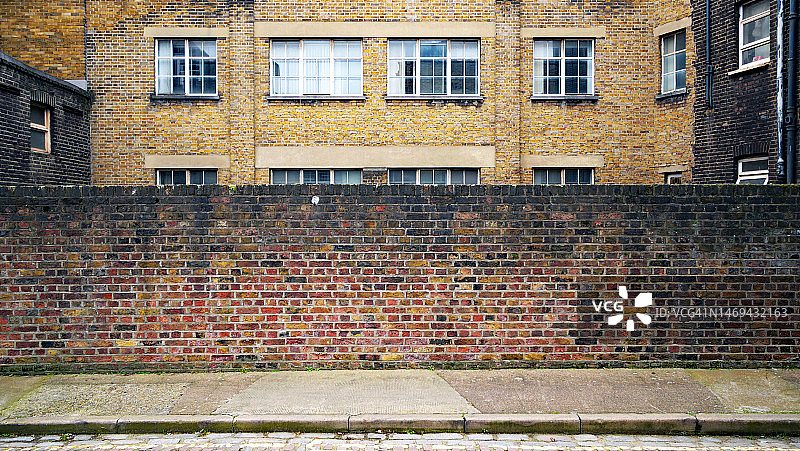 伦敦的旧砖墙、水泥人行道和建筑背面图片素材