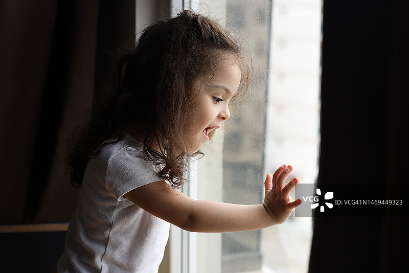 小女孩向窗外看图片素材