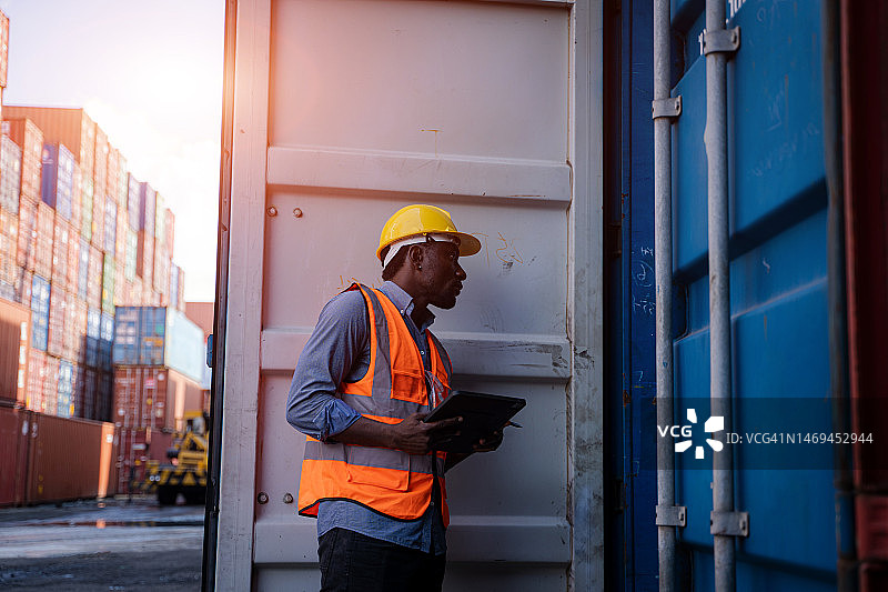 在集装箱堆场使用平板电脑工作的工头或主管图片素材