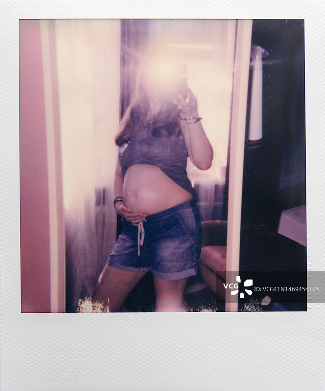 怀孕女性自拍的即时照片图片素材