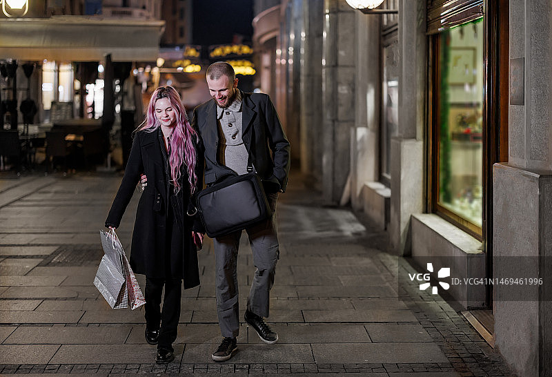快乐的情侣逛完购物中心后在城市漫步图片素材