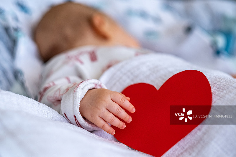 宝宝抱着红色的心睡觉图片素材