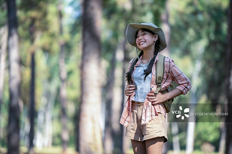 女孩在松林中欣赏自然风光图片素材