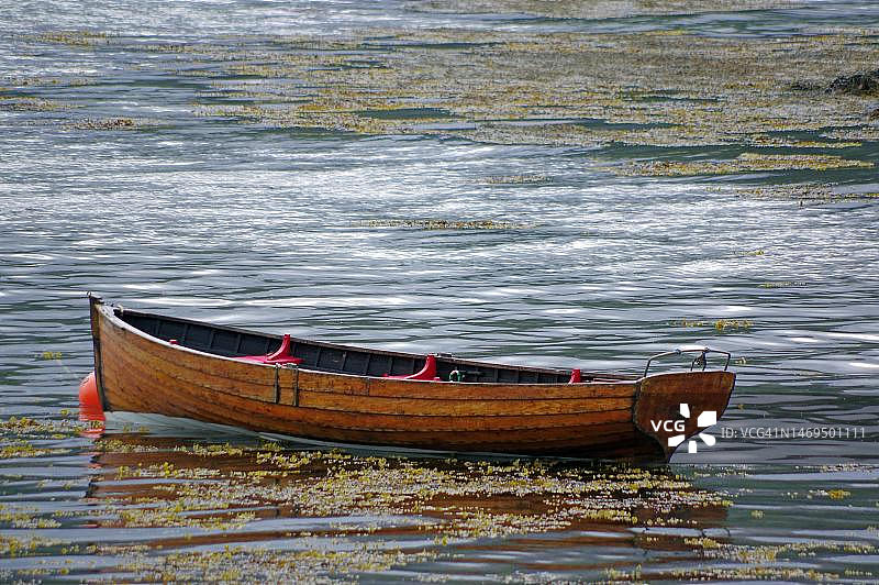 停靠在苏格兰高地普洛克顿港浅水区的小木制划艇图片素材