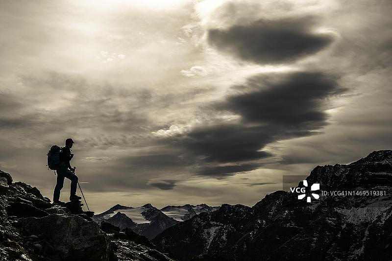逆光山岩上的登山者图片素材