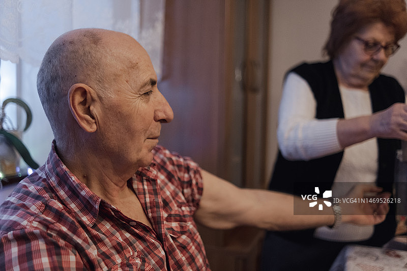 年长的妻子帮助丈夫测量血压图片素材