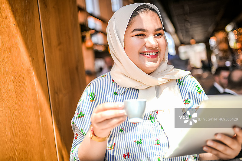使用平板电脑的年轻穆斯林女性图片素材