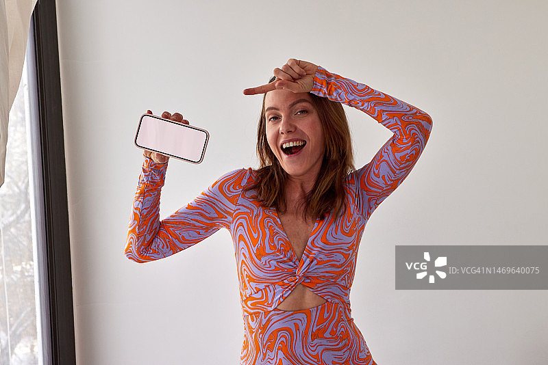 指向白色背景智能手机屏幕的时尚女性图片素材