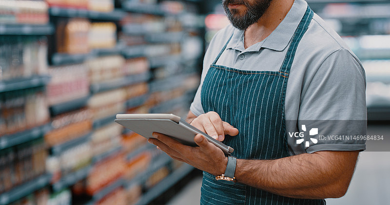超市员工使用平板电脑进行商品管理图片素材