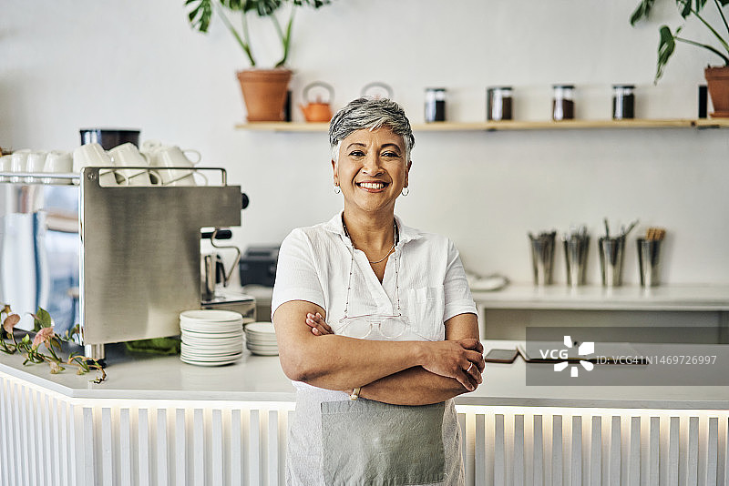 咖啡店里的快乐老年妇女肖像，小企业主、零售和管理，咖啡馆里的女服务员欢迎顾客图片素材