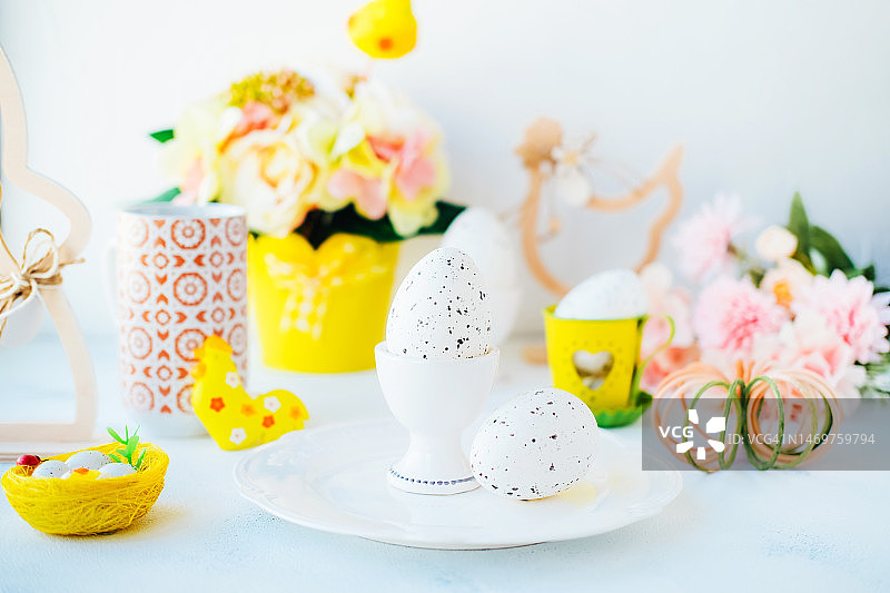 鹌鹑蛋、黄色鸟巢、玩具公鸡、复活节兔子和鲜花图片素材