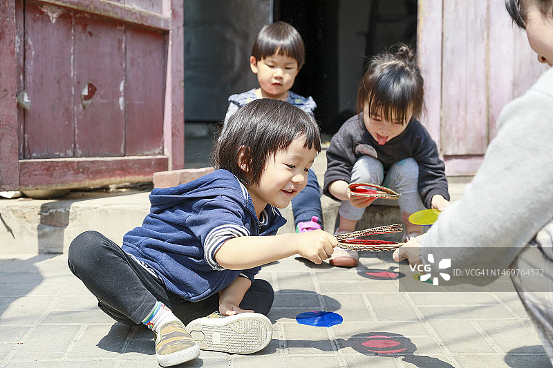男孩和女孩在地上玩彩色影子图片素材
