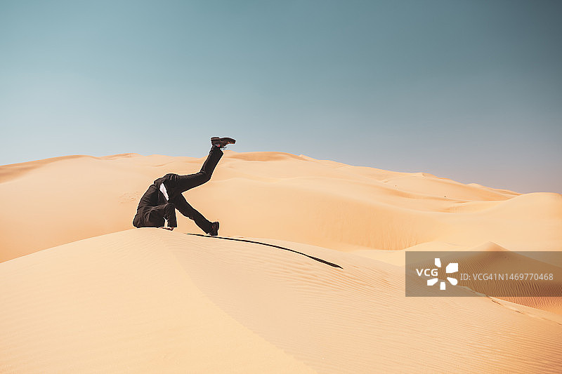 男人把头埋在沙子里-隐喻图片素材