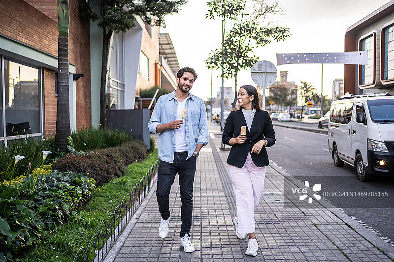 情侣在城市里边走边吃冰淇淋图片素材