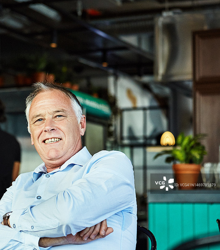 面带微笑难以置信的男人坐在餐厅里图片素材