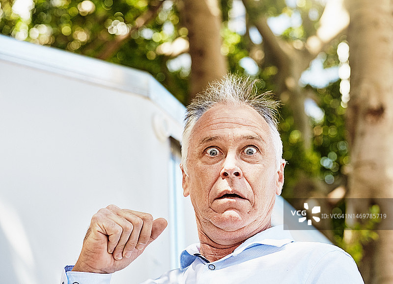 头发蓬乱、眼神狂野的男人震惊地盯着镜头图片素材