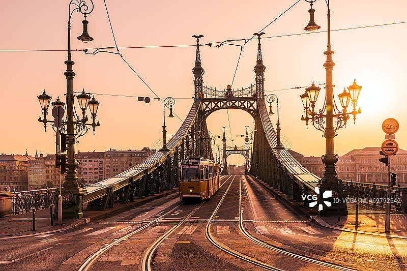 匈牙利布达佩斯日出时分的自由桥和黄色有轨电车图片素材
