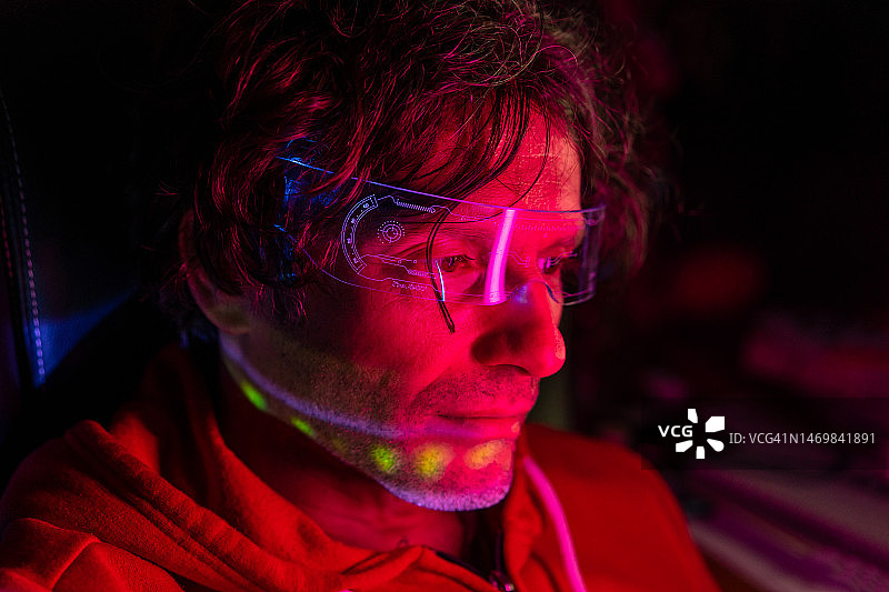 戴着数码眼镜，脸上反射着光线的男人图片素材