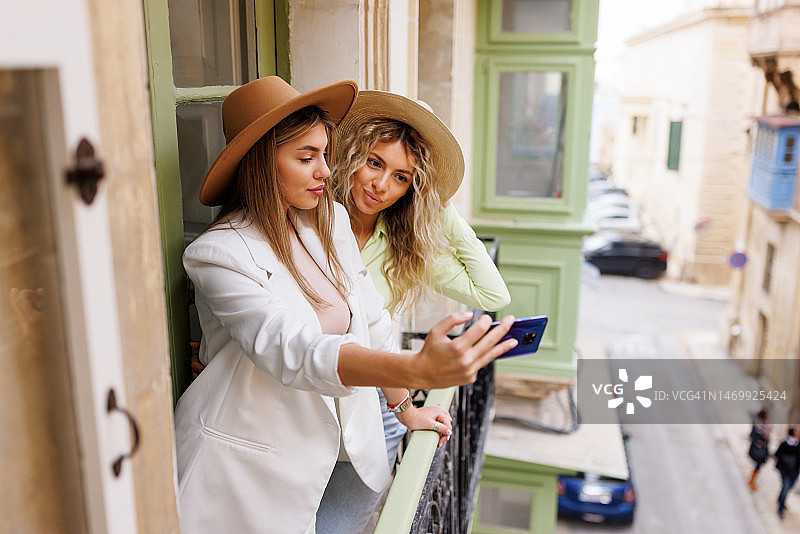 在公寓阳台上自拍的年轻女游客图片素材