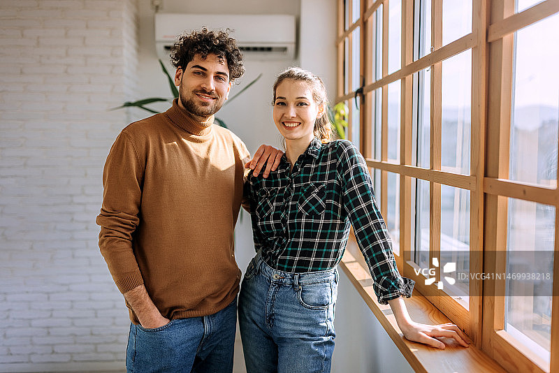两位年轻的同事站在窗边摆姿势拍照图片素材