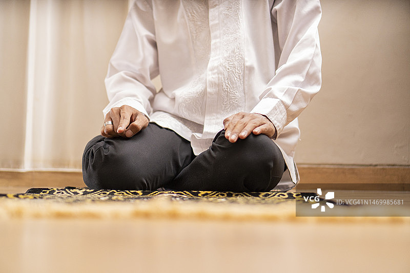 斋月期间在家中张开手掌祈祷的穆斯林男子图片素材