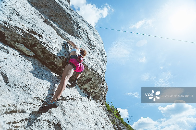 年轻女子攀登悬崖岩石图片素材