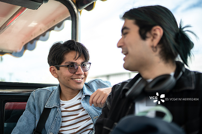 在露天巴士上与朋友交谈的年轻男人图片素材