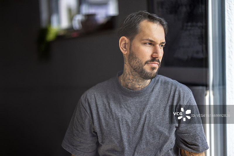 面色严肃的年轻男子望向侧方图片素材