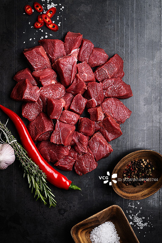 黑色石板上的生牛肉和香料图片素材