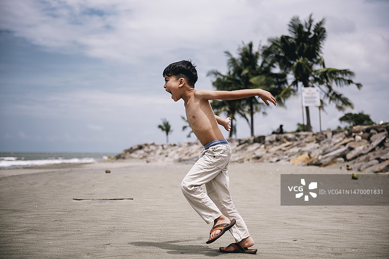 在海滩上奔跑的小男孩图片素材