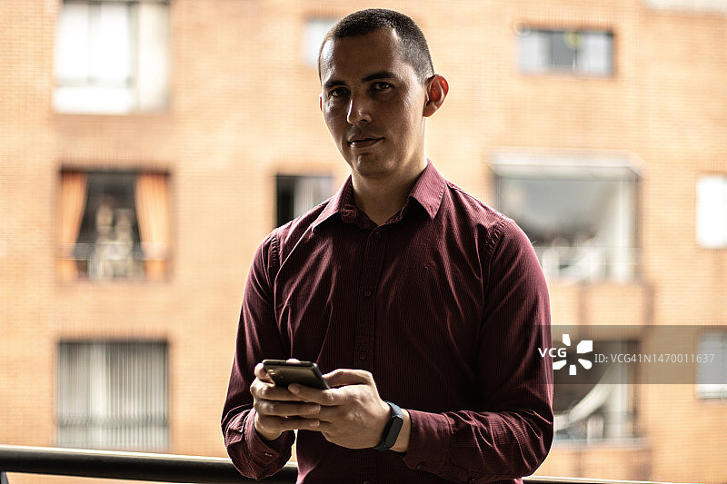在公寓使用手机的中年男人肖像图片素材