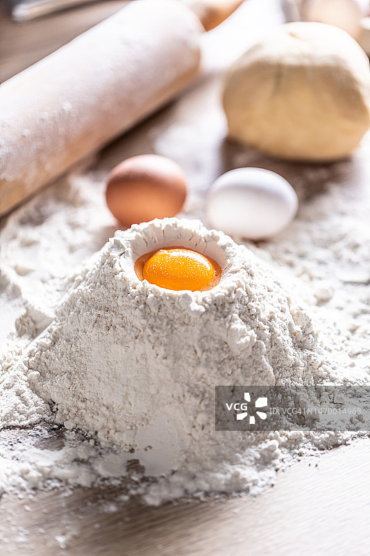 烘焙台上的一勺面粉、鸡蛋和一个擀面杖图片素材