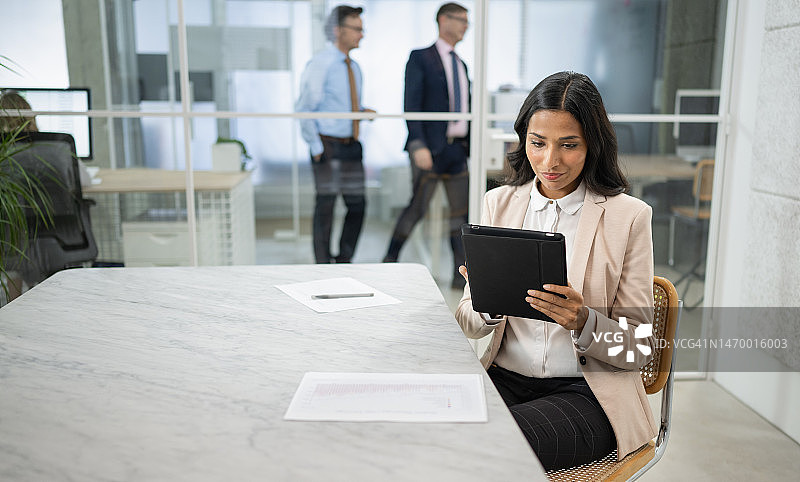 一位年轻女商人工作时使用平板电脑的镜头图片素材