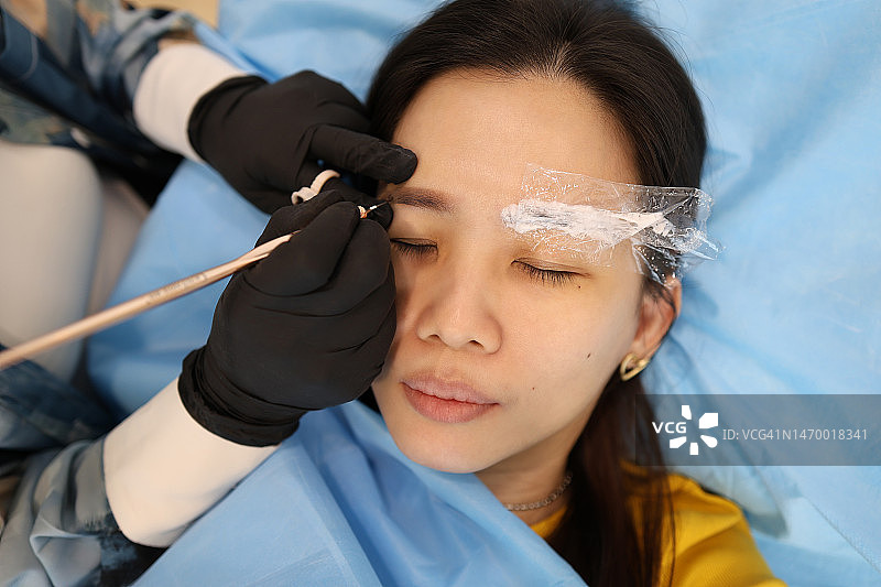 纹绣师正在帮助一位女士纹眉图片素材