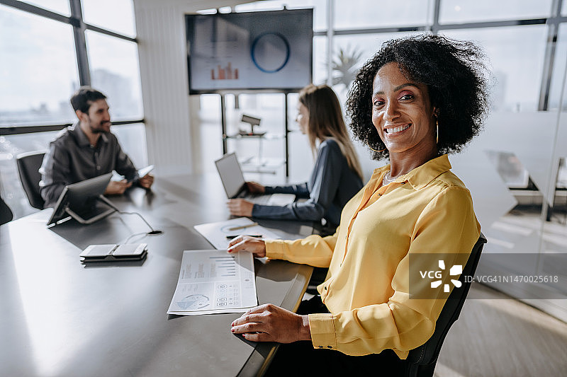 坐在会议桌旁看着镜头的商务女士肖像图片素材