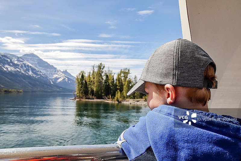 在加拿大艾伯塔省沃特顿湖国家公园沃特顿湖上乘船游览的男孩图片素材