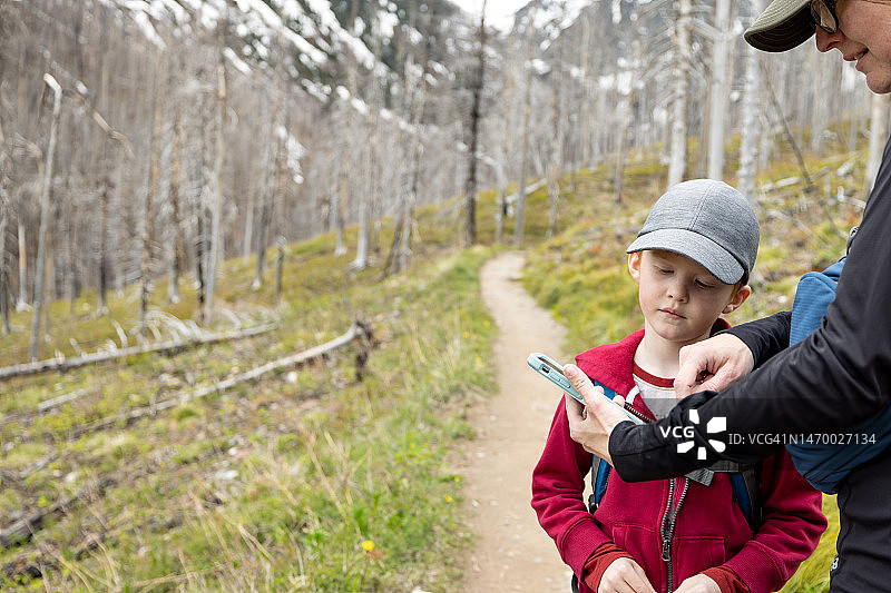 母亲和儿子在加拿大艾伯塔省沃特顿湖国家公园的克兰德尔湖步道徒步旅行图片素材