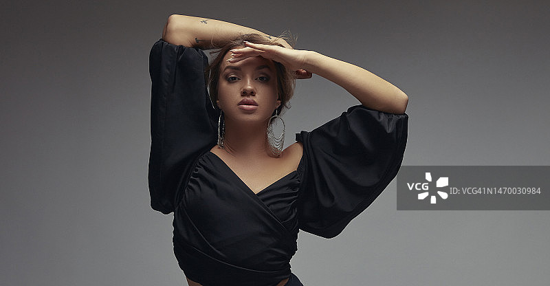 身穿胸衣的漂亮女人手扶额头，眺望远方镜头的肖像图片素材