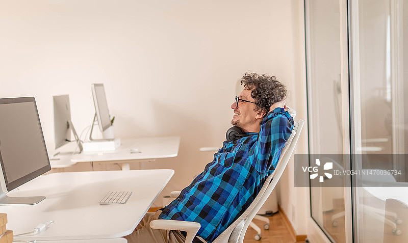 快乐的年轻人戴着眼镜在工作日放松身心图片素材