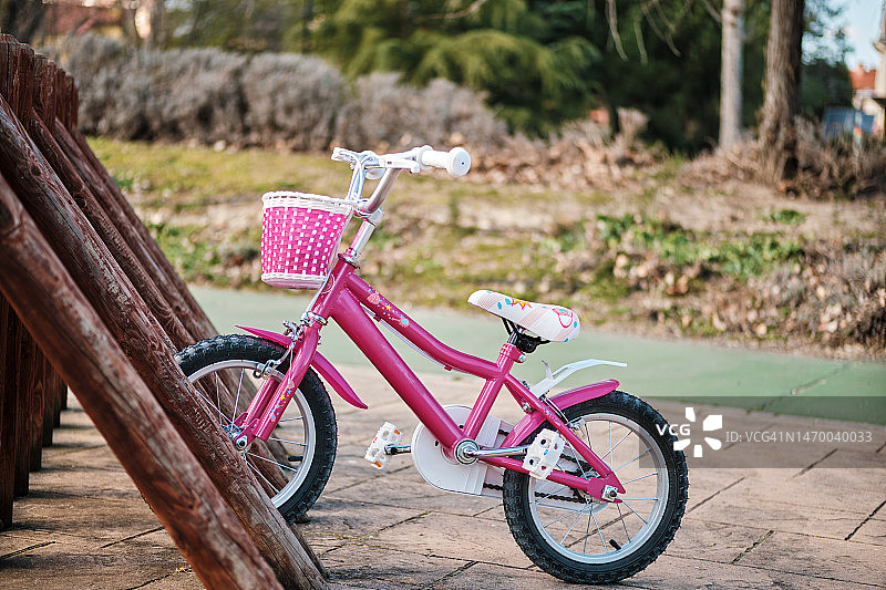 阳光明媚的一天停放的粉色自行车图片素材