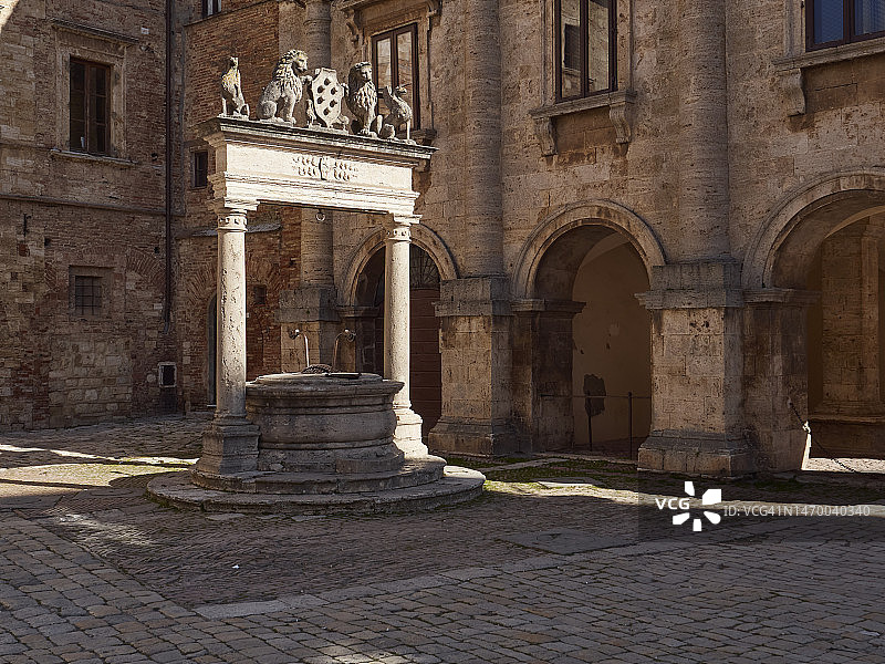 托斯卡纳蒙特普尔恰诺主广场的水井与带有六个球的梅迪奇盾牌图片素材