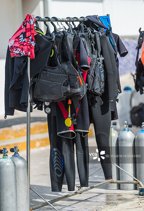 潜水店外的架子上的氧气罐、湿式潜水服和水肺潜水设备图片素材