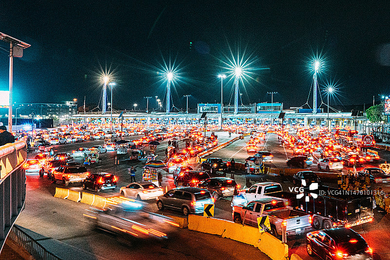 美国加利福尼亚州圣迭戈与墨西哥蒂华纳边境，等待过境的汽车和建筑卡车慢快门图像图片素材