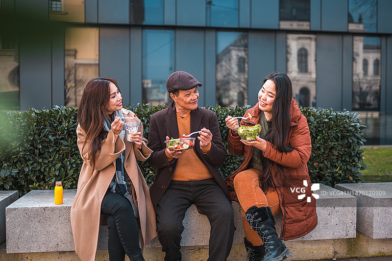 亚洲家庭在城市户外享用健康的午餐图片素材