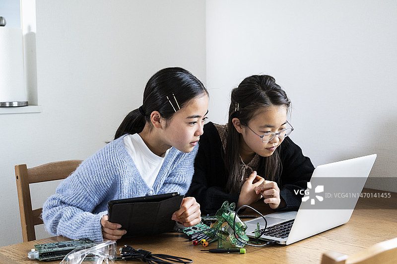 青少年姐妹一起组装机器人图片素材