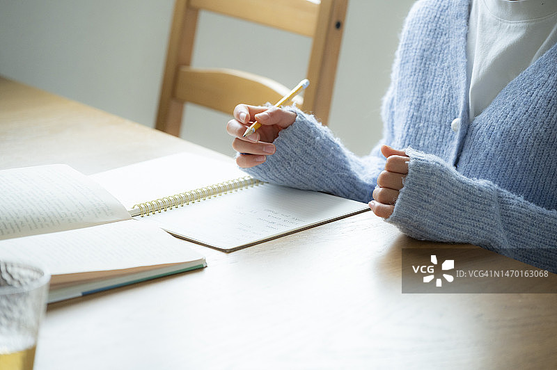 女孩在桌旁写作业图片素材